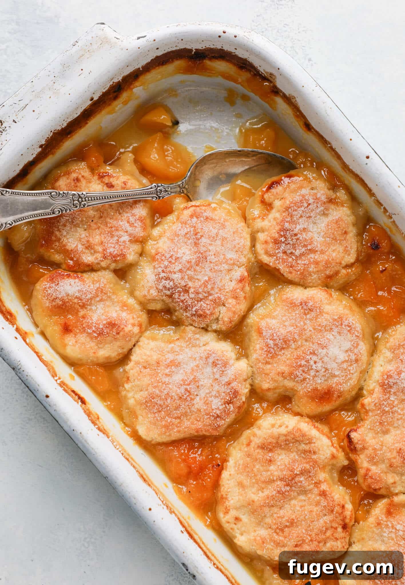 Southern Comfort Peach Cobbler 2 Old Fashioned Peach Cobbler baked in a vintage dish, showcasing its golden-brown biscuit topping and bubbling peach filling.