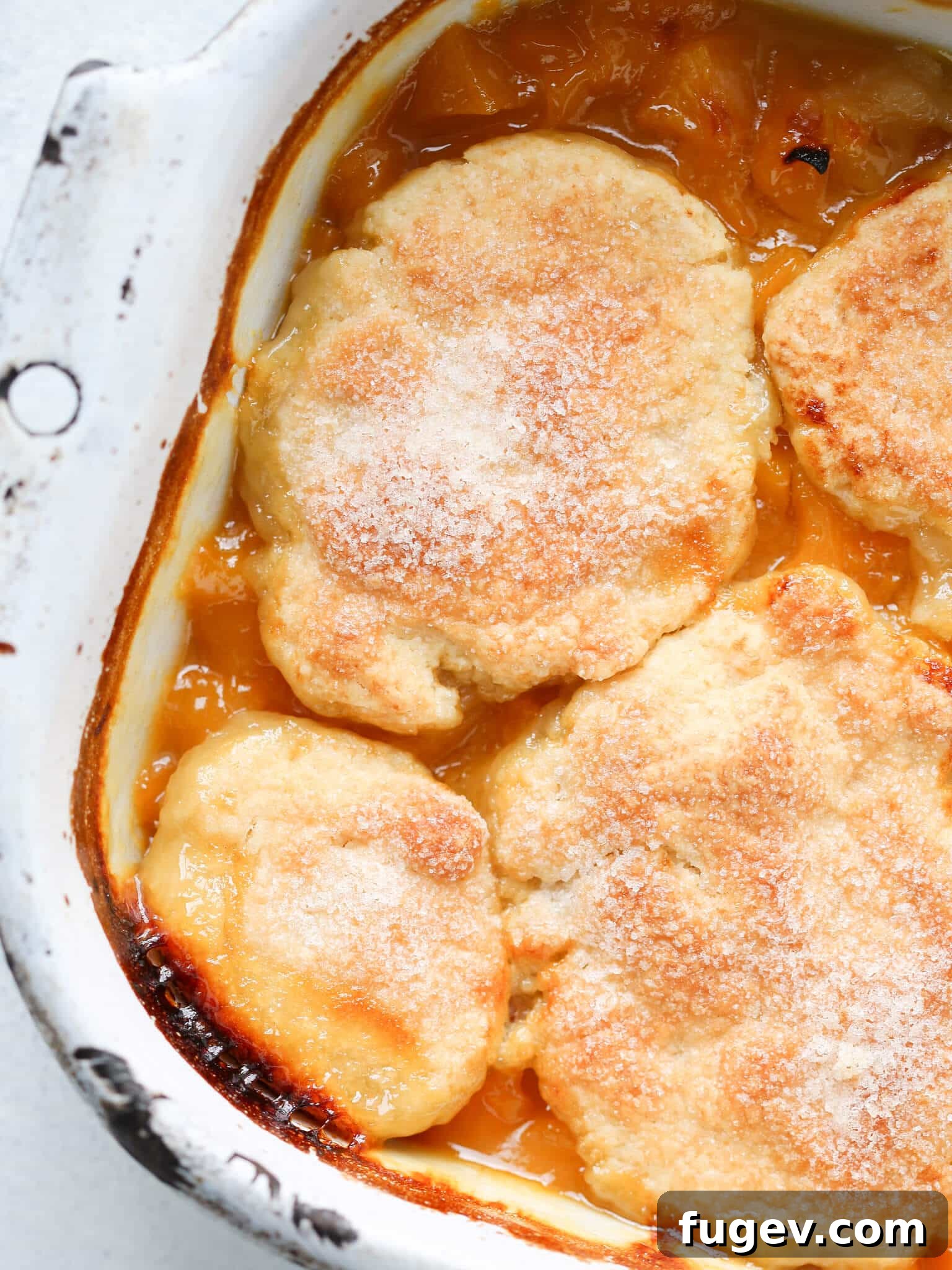 Southern Comfort Peach Cobbler 4 Close-up of peach cobbler's sugared biscuit topping, showing its flaky texture.
