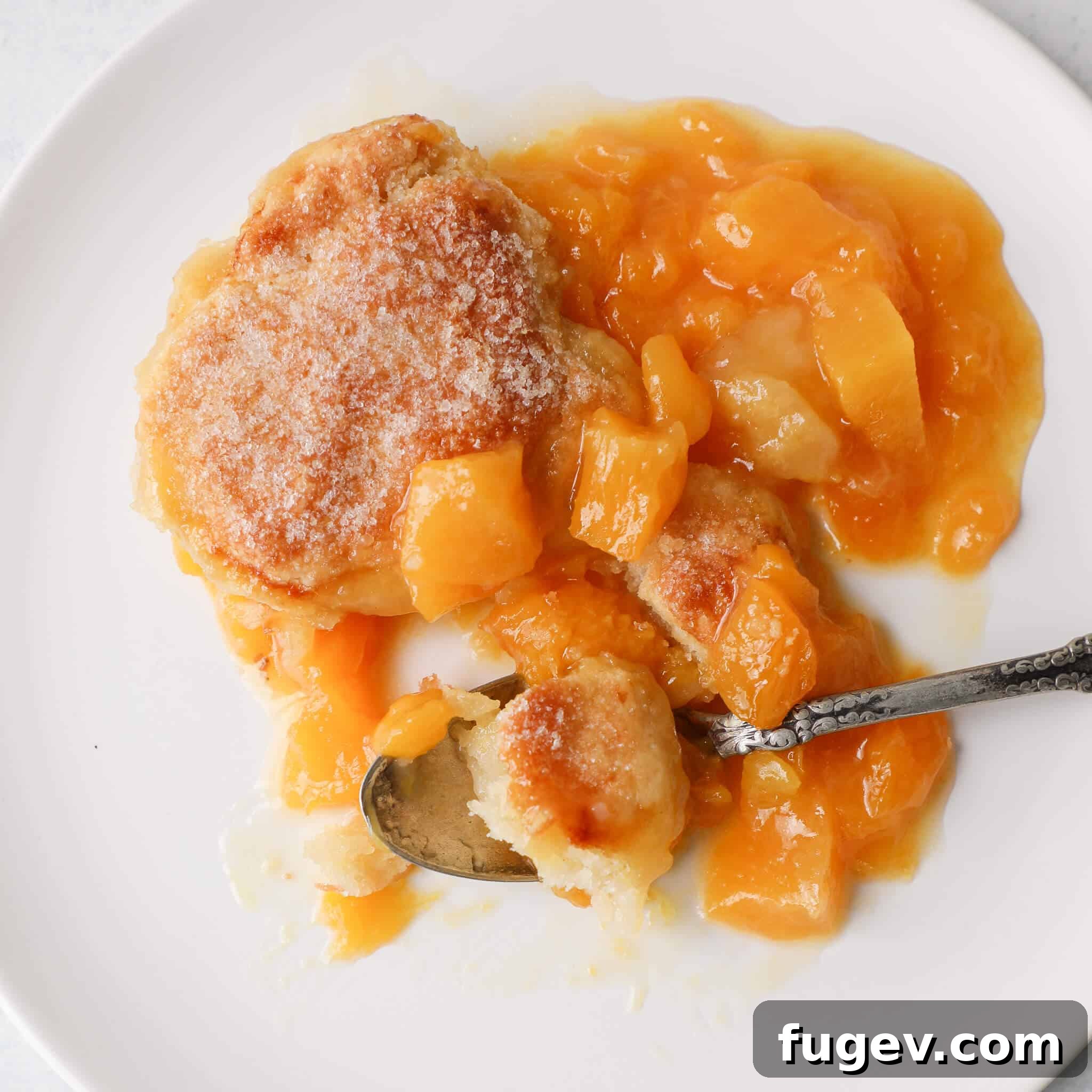 Southern Comfort Peach Cobbler 5 Dessert with peaches served on a plate, garnished and ready to eat.
