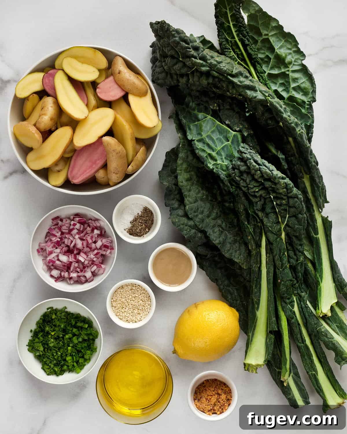Emerald & Gold Potato Salad 3 All the fresh ingredients laid out: fingerling potatoes, kale, red onions, chives, parsley, sesame seeds, olive oil, tahini, and lemon.