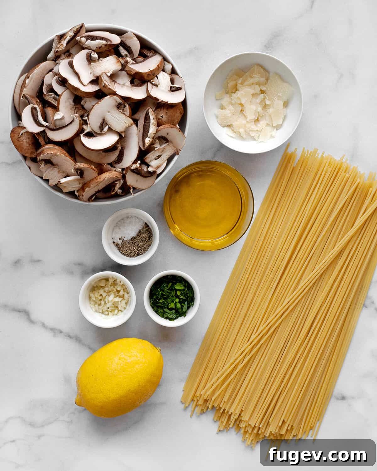 Lemon-Kissed Garlic Mushroom Pasta 3 A vibrant flat lay showcasing all the fresh ingredients needed for lemon garlic mushroom spaghetti: cremini mushrooms, spaghetti, fresh lemon, minced garlic, high-quality olive oil, Parmesan cheese, and fresh parsley.