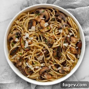 Lemon garlic mushroom spaghetti served in a beautiful white bowl, garnished with fresh herbs.