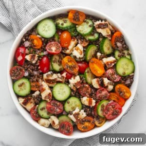 Mediterranean Grilled Halloumi Lentil Salad 8 Lentil salad with grilled halloumi, cucumbers and tomatoes in a large bowl.