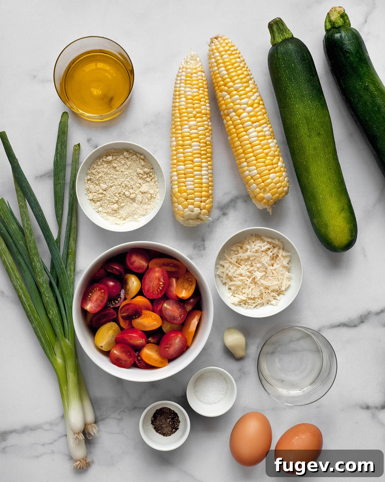 Golden Baked Zucchini Corn Fritters 3 Key ingredients for zucchini corn fritters and tomato salad, including fresh zucchini, corn, parmesan, scallions, cherry tomatoes, and olive oil.