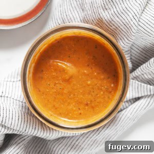 Golden Harvest Roasted Tomato Dressing 7 A beautifully presented mason jar filled with the vibrant red, freshly made roasted tomato vinaigrette, ready to be stored or served.