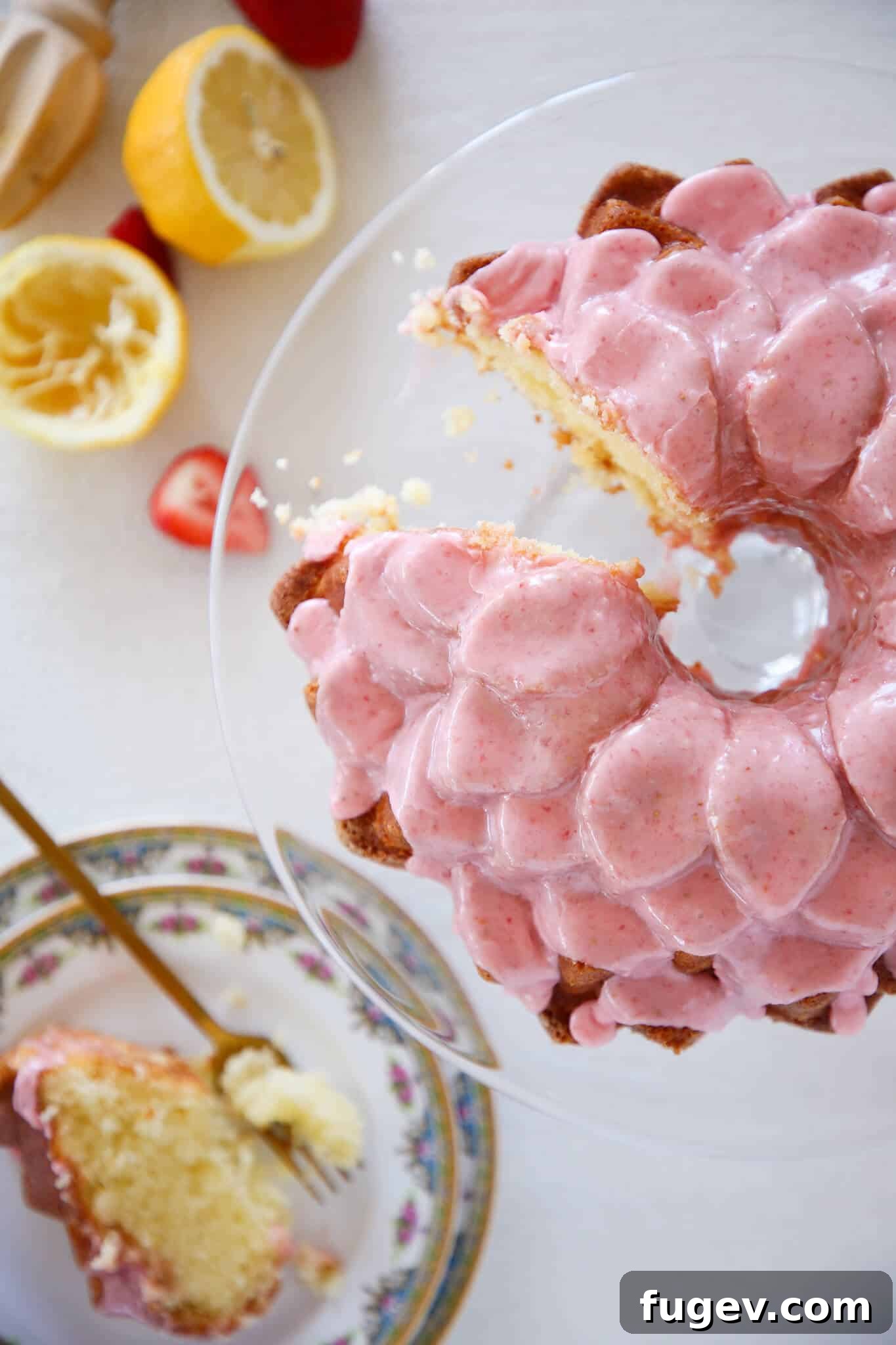Zesty Lemon Loaf 2 A beautifully sliced Lemon Pound Cake with fresh strawberry icing, presented on an elegant glass pedestal, ideal for Valentine's Day, Spring gatherings, or any special occasion.