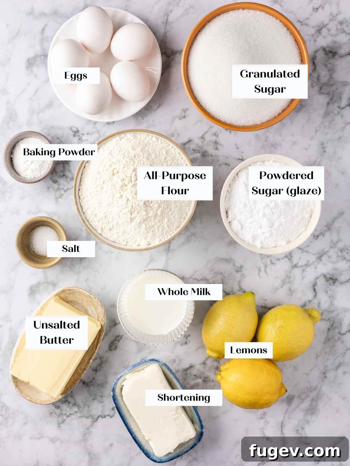 Zesty Lemon Loaf 4 All the essential ingredients for a delicious Lemon Pound Cake and strawberry icing, neatly arranged on a pristine white marble countertop.