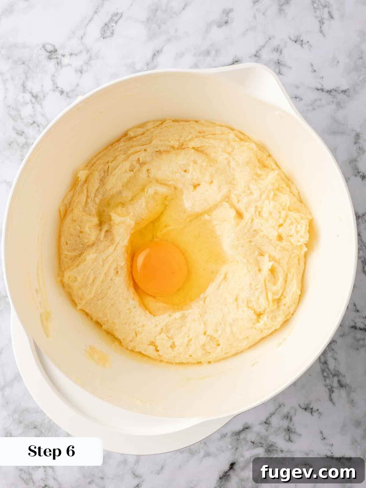 Zesty Lemon Loaf 6 Adding eggs one by one to the lemon pound cake batter, ensuring each is fully incorporated before the next addition.