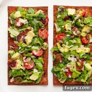 Two lavash bread pizzas topped with mixed greens.