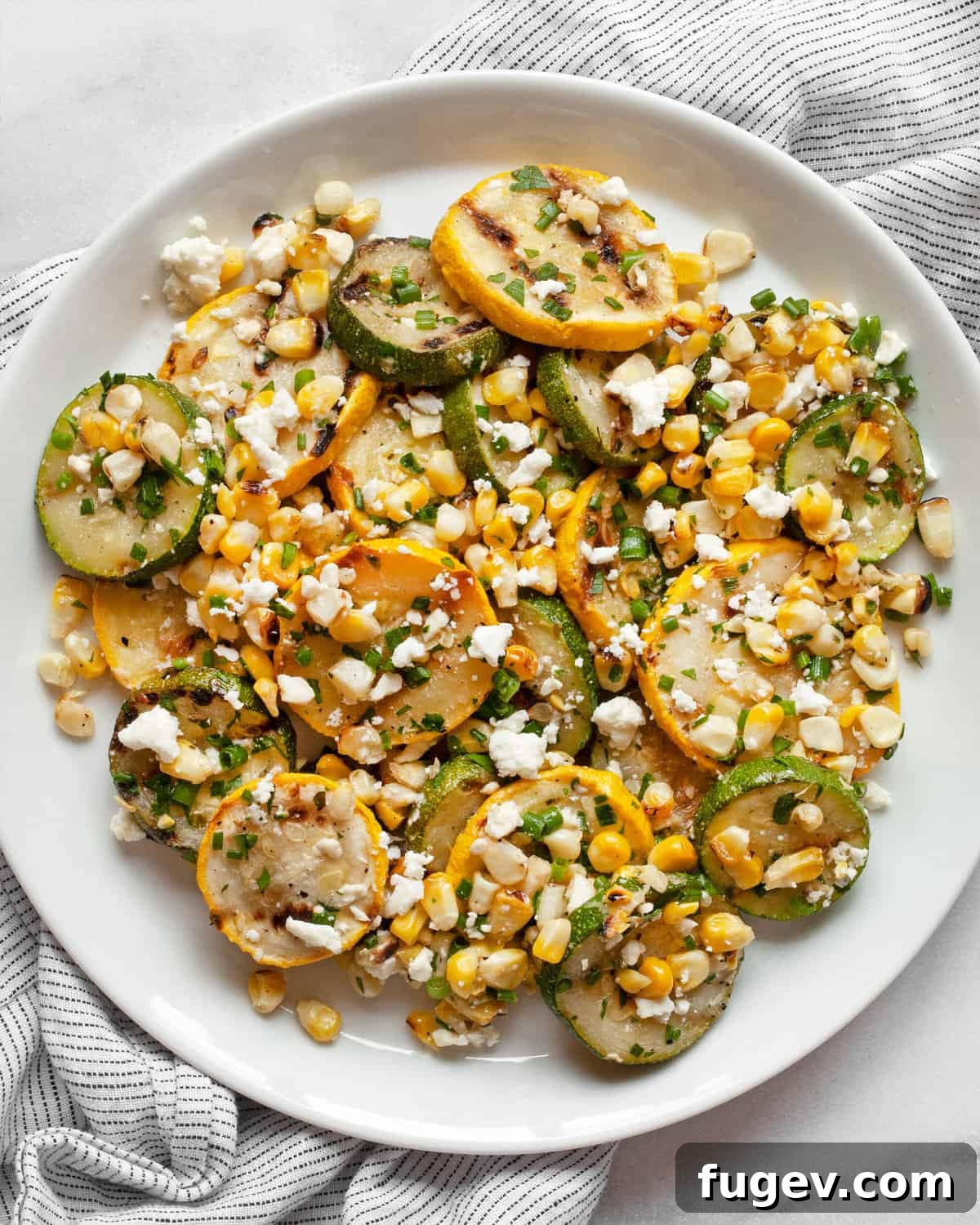 Summer Grilled Veggie Medley 2 Grilled zucchini, squash and corn on a plate, garnished with fresh herbs and feta.