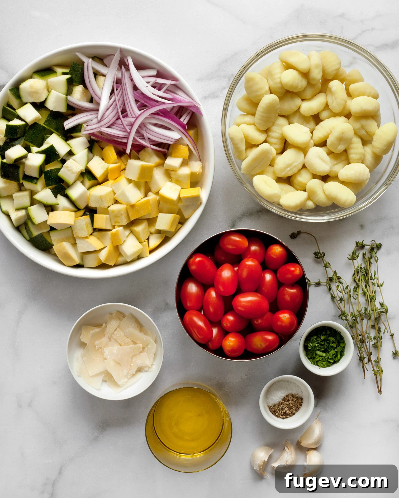 Sheet Pan Gnocchi Harvest 3 Raw ingredients laid out for sheet pan gnocchi, including gnocchi, zucchini, yellow squash, grape tomatoes, red onion, and garlic.
