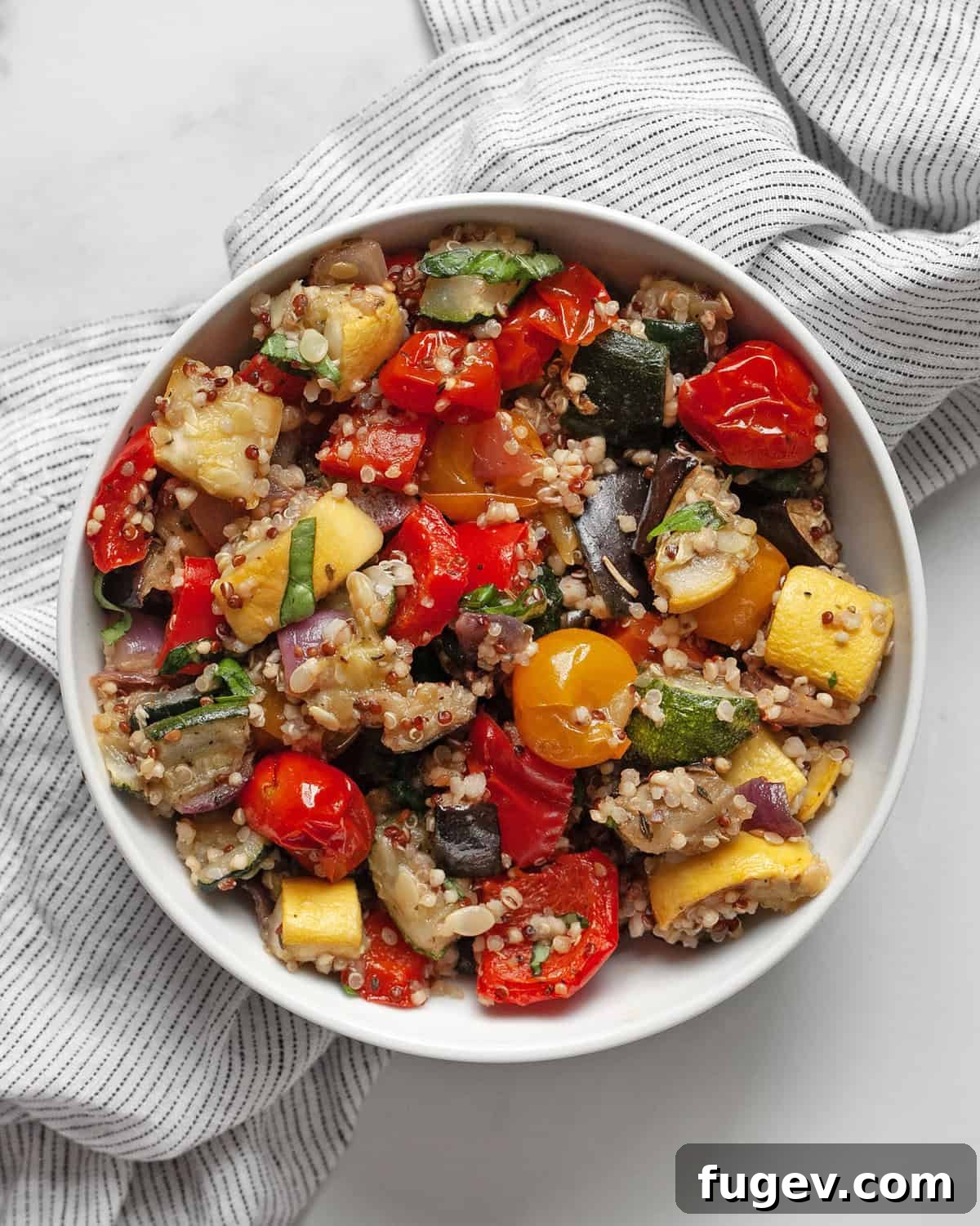 Sun-Kissed Ratatouille & Quinoa Medley 2 A small bowl of roasted ratatouille quinoa, showcasing vibrant vegetables and fluffy grains, ready to be enjoyed as a wholesome vegan meal.