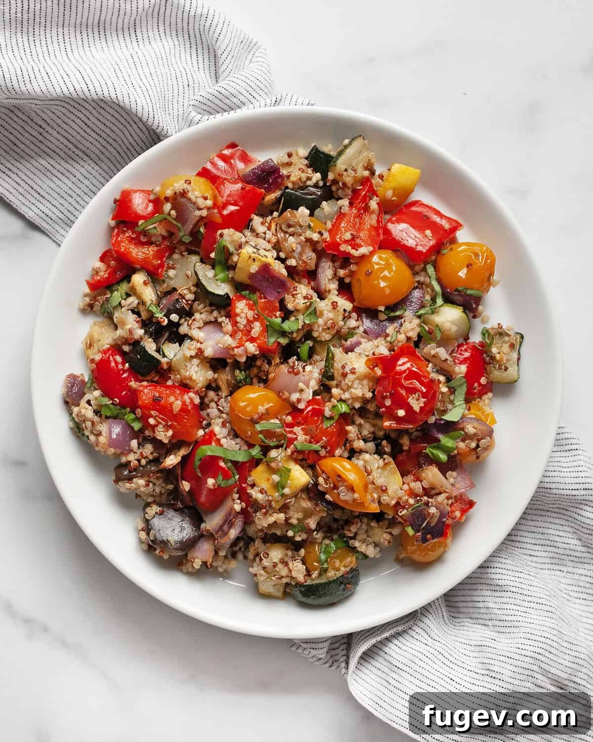 Sun-Kissed Ratatouille & Quinoa Medley 8 A serving of roasted ratatouille quinoa neatly plated, garnished with fresh basil, ready to be enjoyed as a wholesome and flavorful vegan meal.