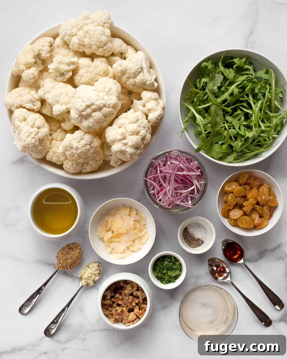 Crisp Cauliflower Salad with Walnuts and Tangy Pickled Raisins 3 Ingredients including cauliflower, arugula, red onions, Parmesan, raisins, olive oil and vinegar.
