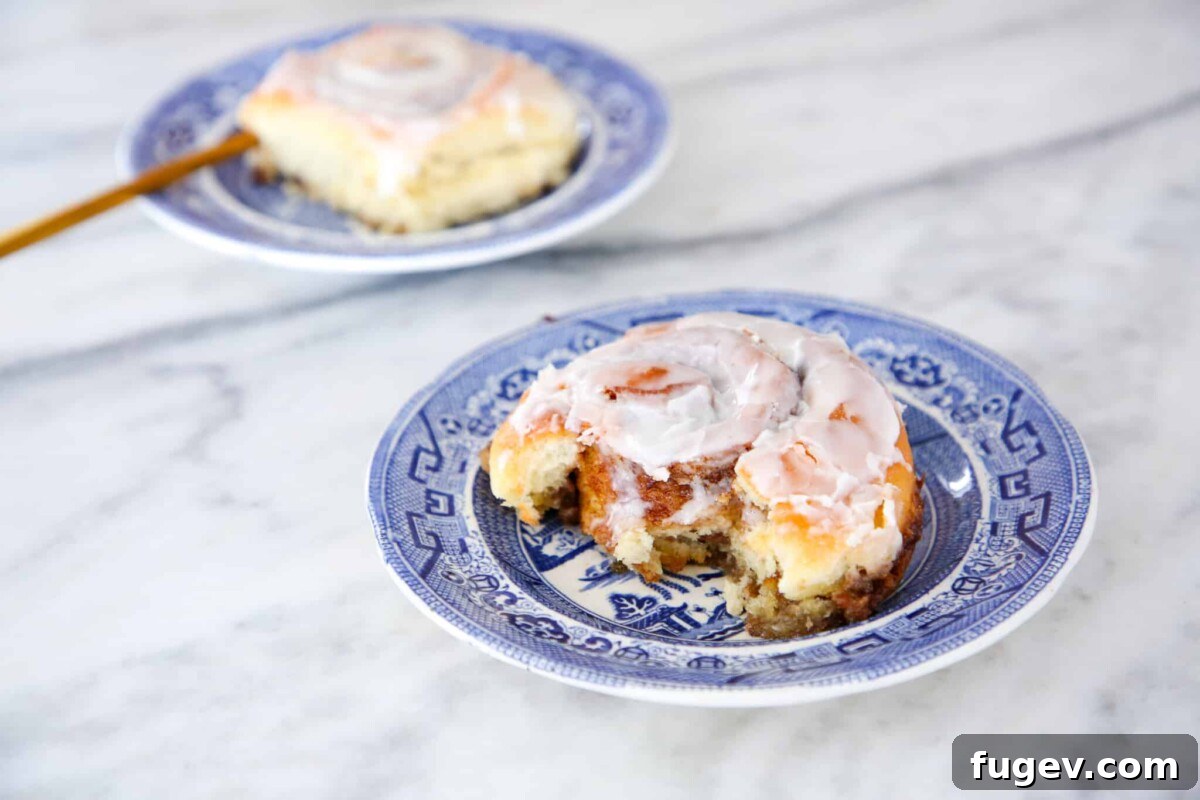Fluffy Sourdough Cinnamon Rolls 4 Beautifully baked sourdough cinnamon rolls arranged neatly in a baking dish, showcasing their golden-brown tops and rich cinnamon swirls, glistening with melted filling.