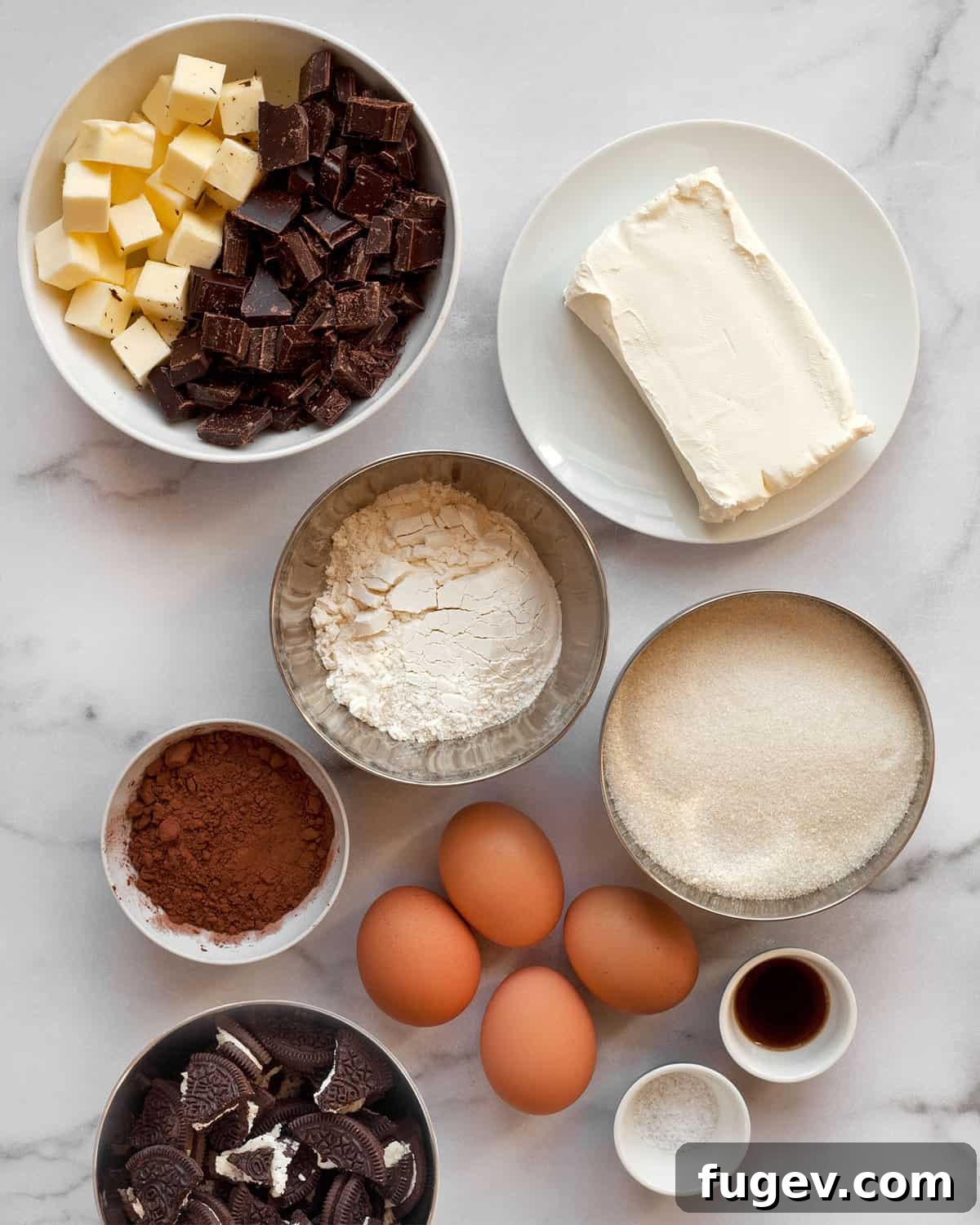 Swirled Cream Cheese Brownies 3 Various baking ingredients laid out on a table, including chopped bittersweet chocolate, cocoa powder, sugar, flour, butter, cream cheese, eggs, and salt, ready for making cream cheese brownies.