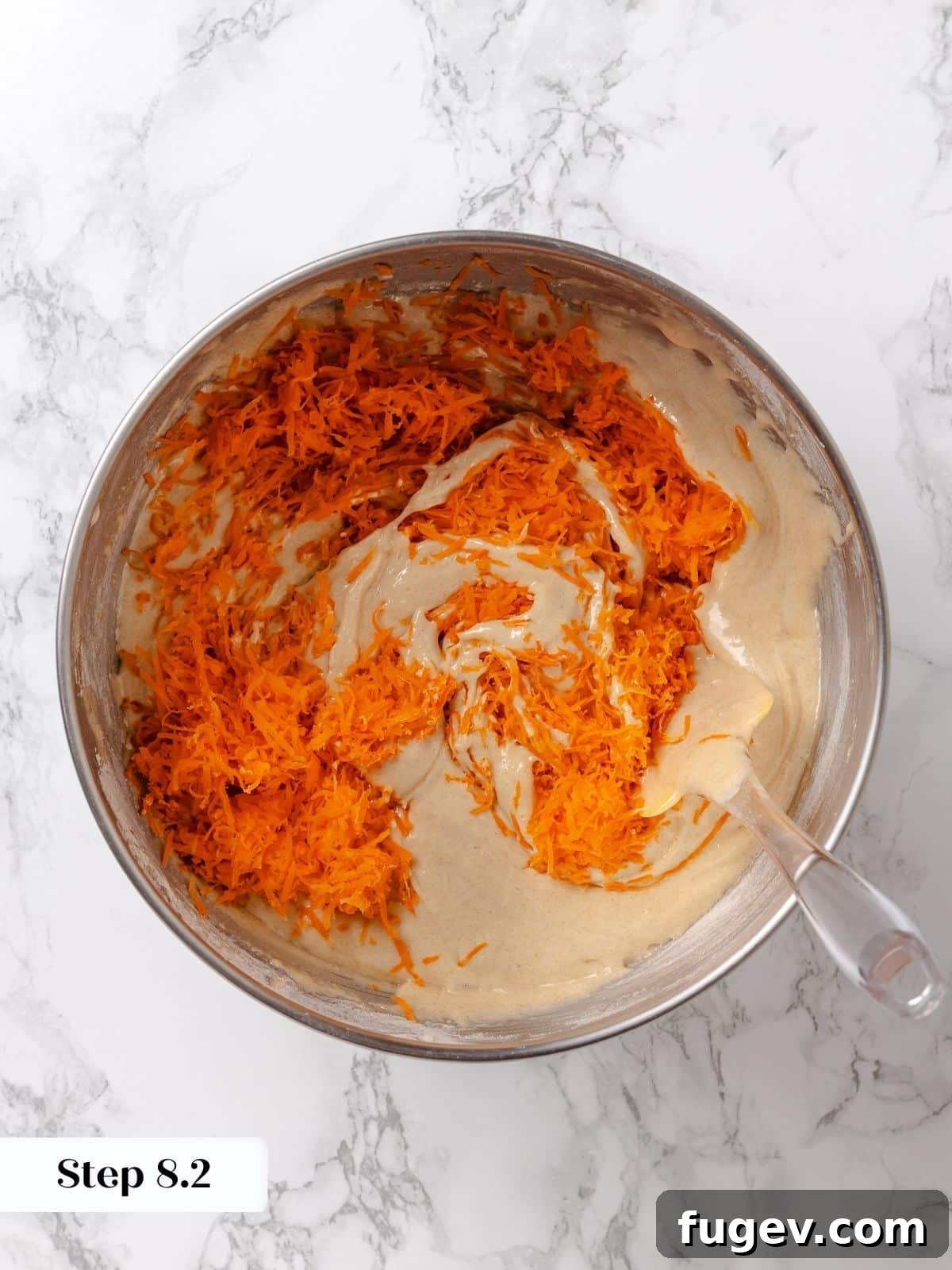 Irresistible Homemade Carrot Cake 11 Freshly grated and squeezed carrots being added to the cake batter, showing their vibrant orange color.