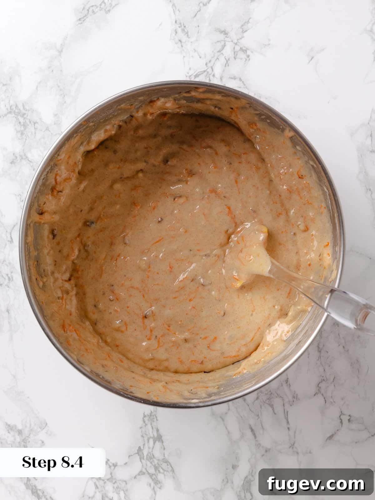 Irresistible Homemade Carrot Cake 13 The perfectly mixed carrot cake batter, rich with carrots and walnuts, in a mixing bowl, ready to be poured into pans.