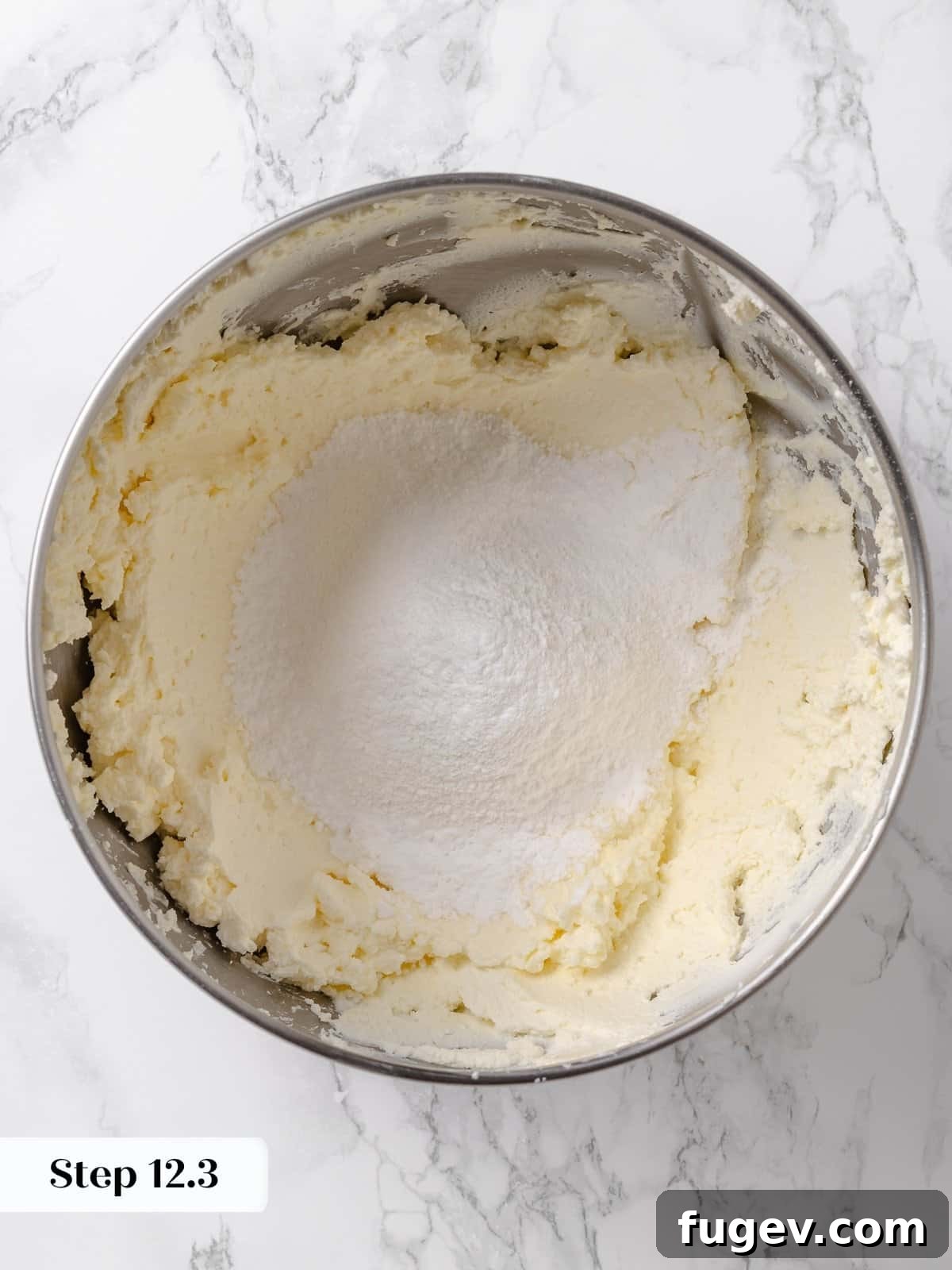 Irresistible Homemade Carrot Cake 18 Sifted powdered sugar being added to the mixer bowl with the creamed butter and cream cheese for frosting.
