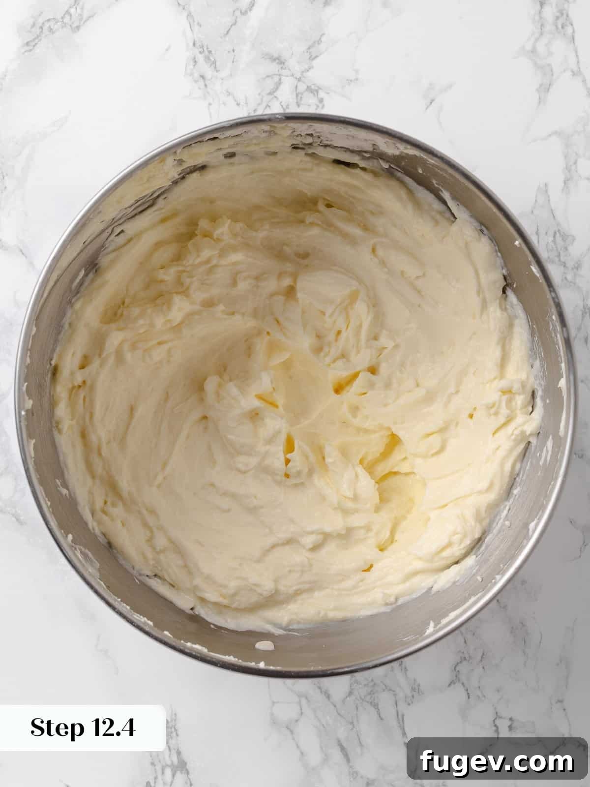 Irresistible Homemade Carrot Cake 19 More powdered sugar being added to the bowl of frosting, contributing to its creamy texture.