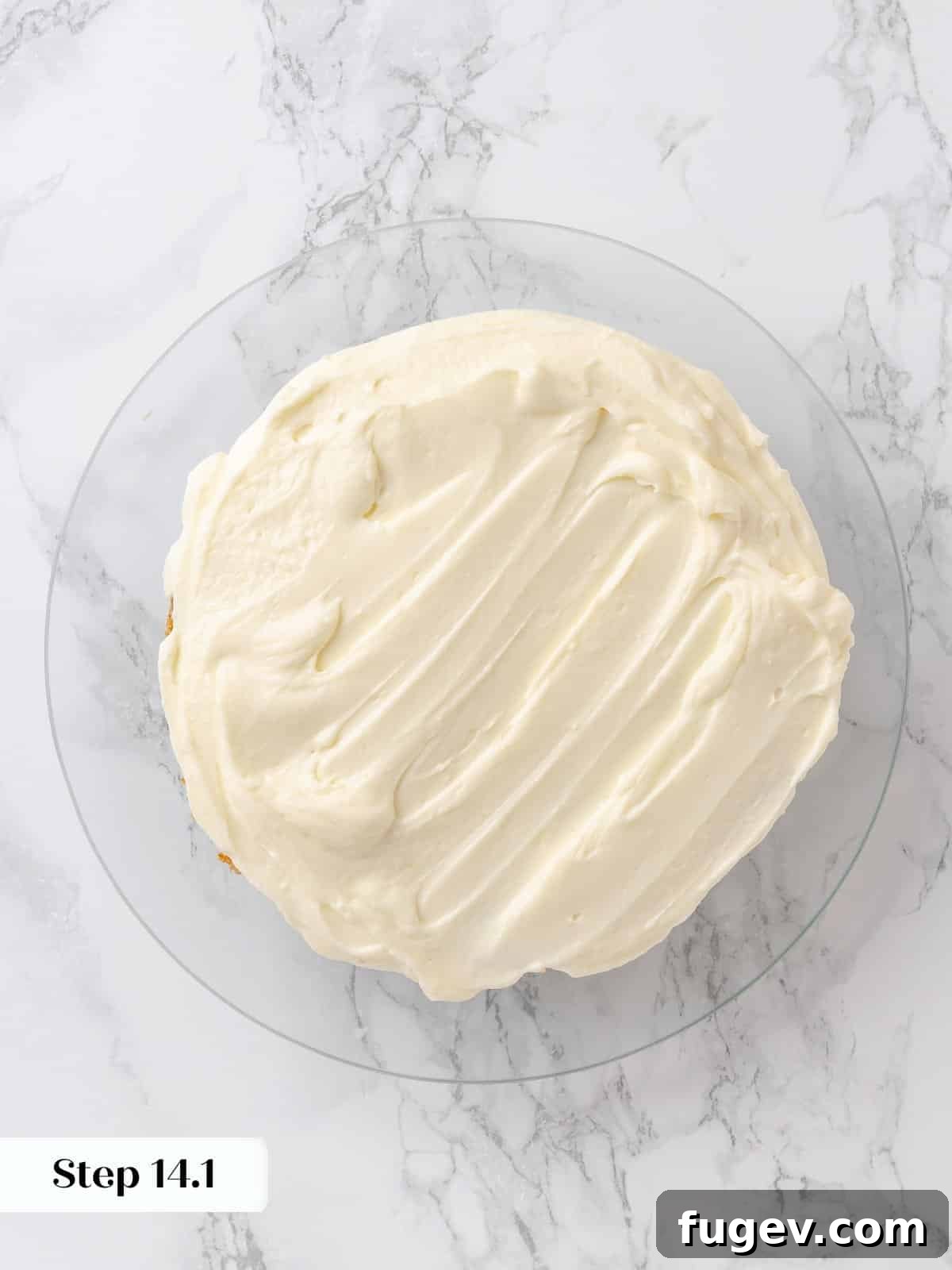 Irresistible Homemade Carrot Cake 22 The first cake layer perfectly covered with a generous, even spread of cream cheese frosting.