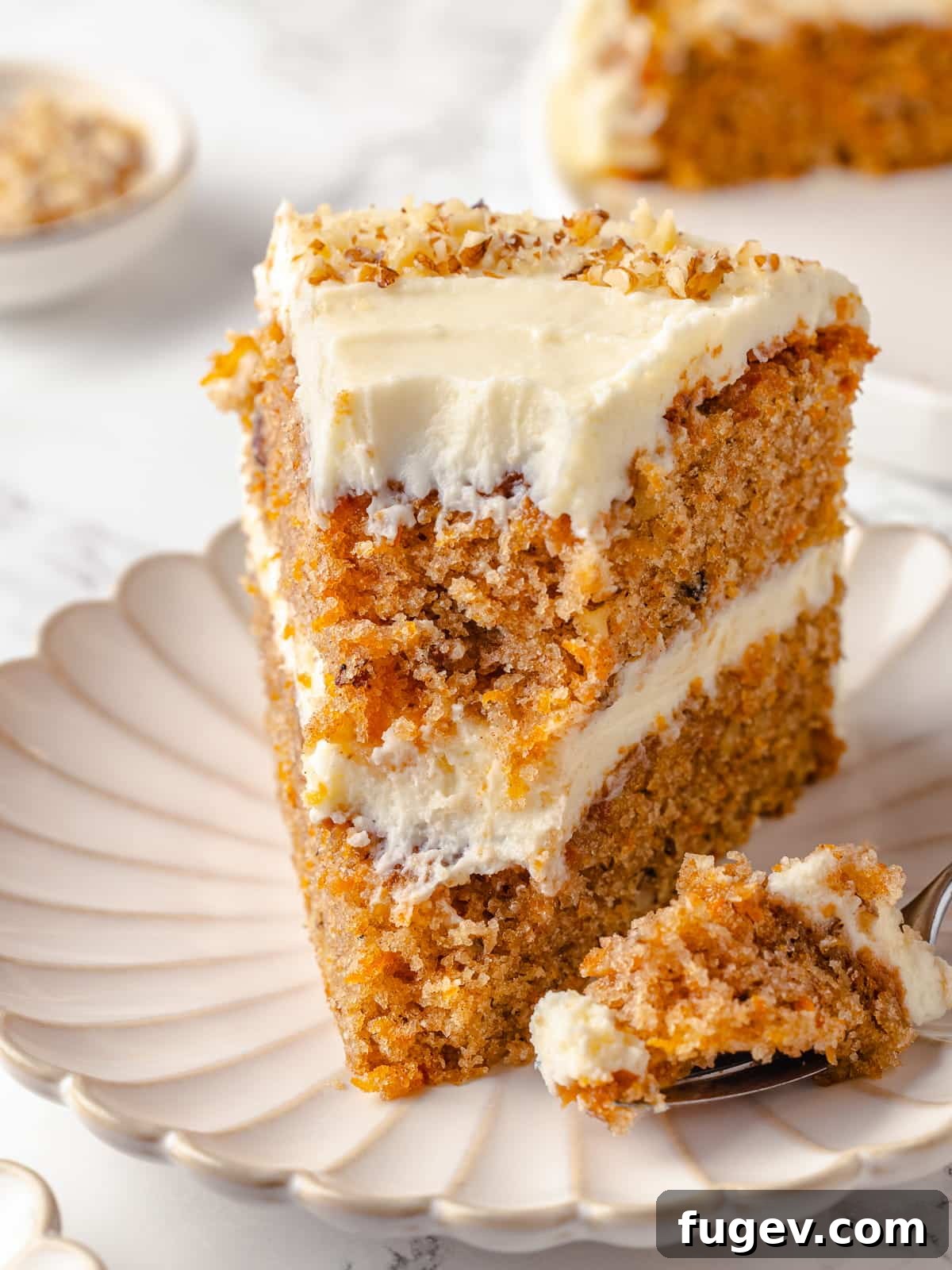Irresistible Homemade Carrot Cake 23 A delectable slice of carrot cake on a white plate, with a fork taking a bite, showing the soft, moist crumb and creamy frosting.