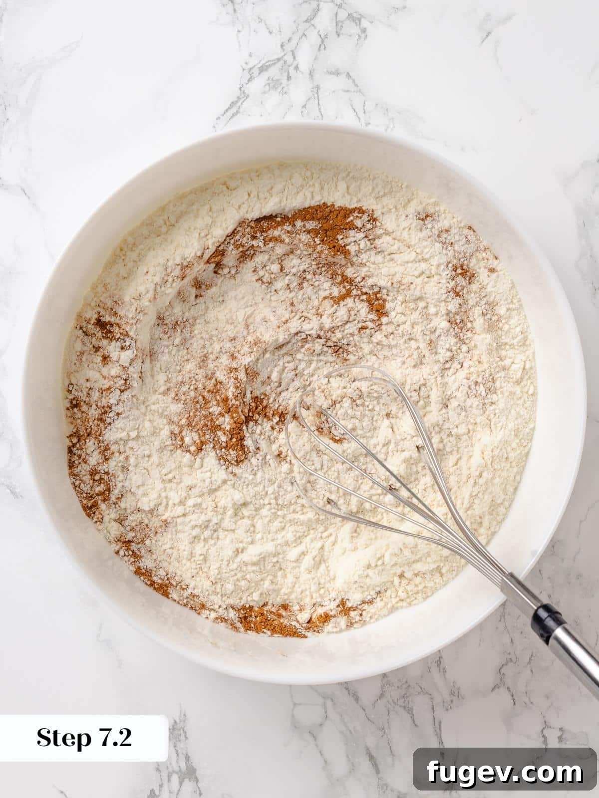 Irresistible Homemade Carrot Cake 9 A rubber spatula gently folding dry ingredients into the whipped wet batter, showing streaks of flour still visible.