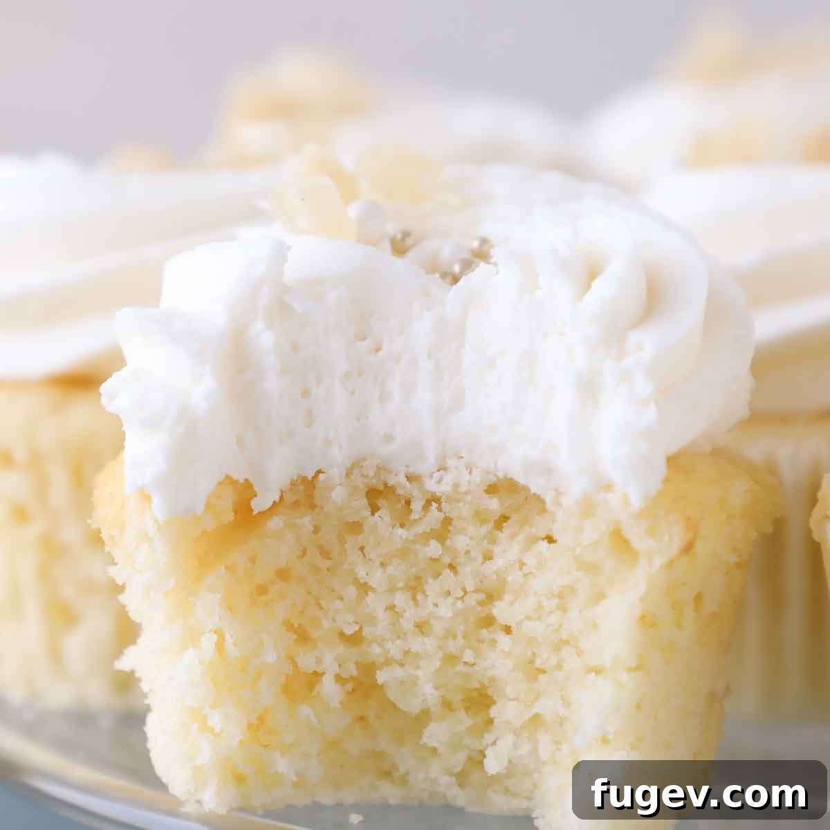 Sunshine Lemon Cloud Frosting 3 Close-up of fluffy interior of lemon buttercream frosting on a cupcake, showing its light and airy texture.