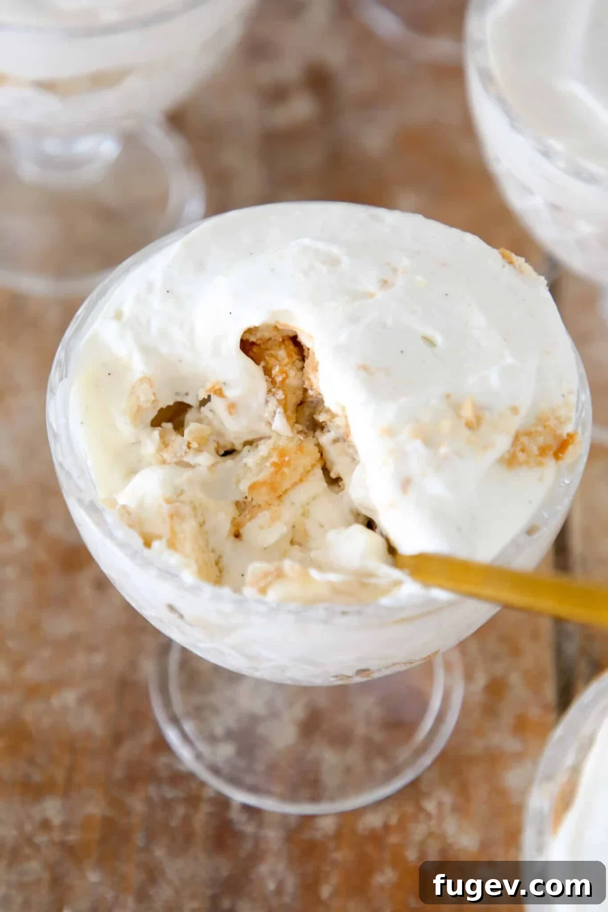 Southern Banana Bliss 2 Delicate banana pudding served in a small glass dish with a golden spoon, highlighting its creamy layers.
