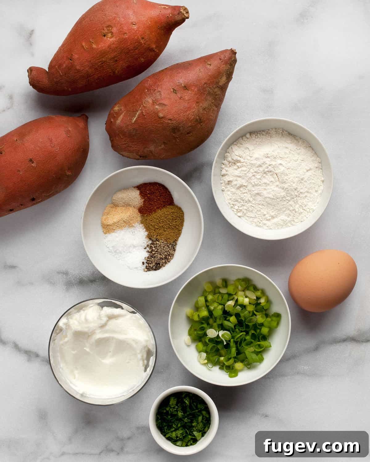 Golden Sweet Potato Fritter Bites 3 A vibrant flat lay showcasing the fresh ingredients for sweet potato fritters: whole sweet potatoes, a selection of aromatic spices, all-purpose flour, a fresh egg, and thinly sliced scallions.