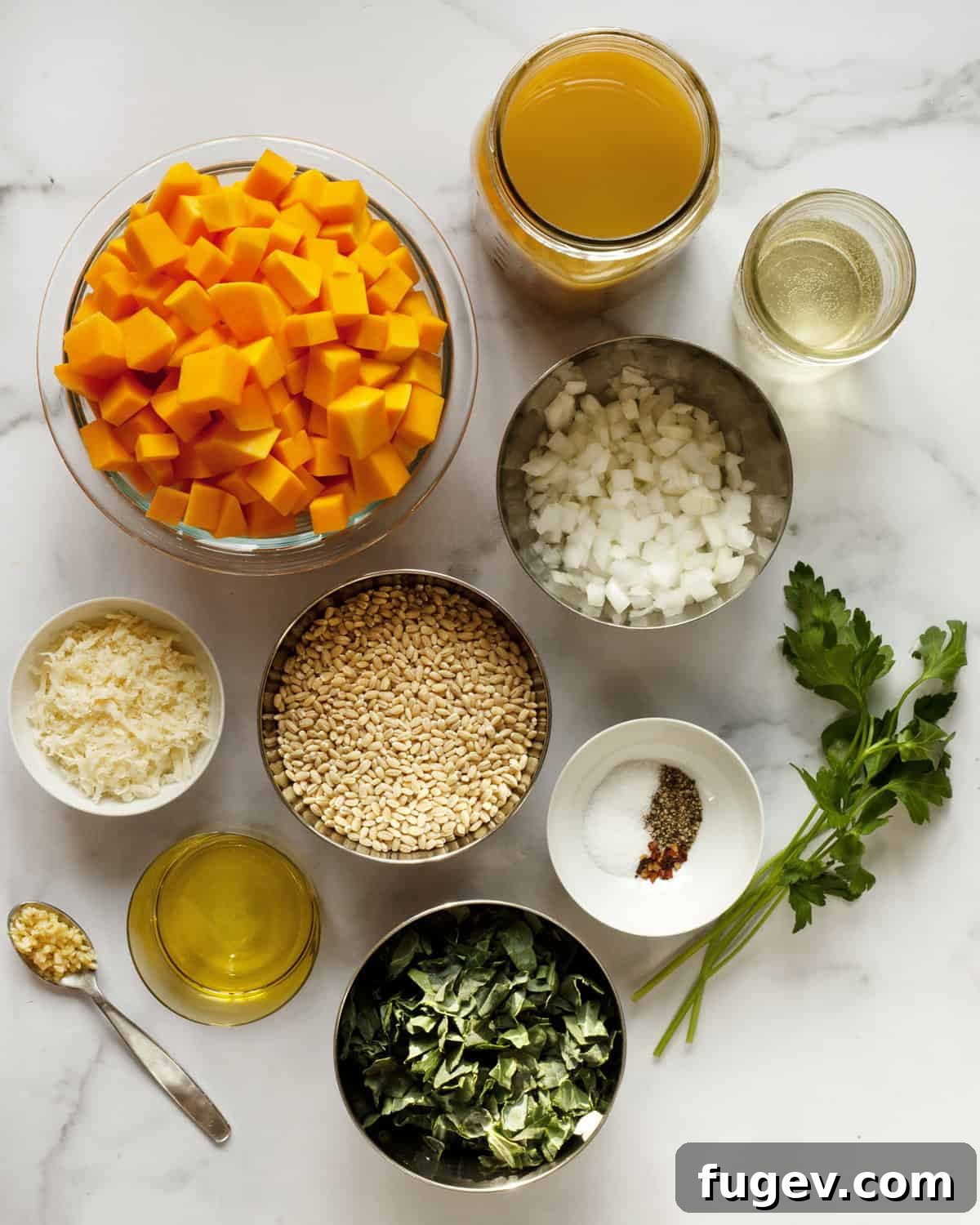 Velvety Baked Butternut Risotto 3 A vibrant selection of ingredients for butternut squash barley risotto, including pearl barley, cubed butternut squash, fresh kale, onions, garlic, vegetable broth, olive oil, parmesan cheese, and seasonings.