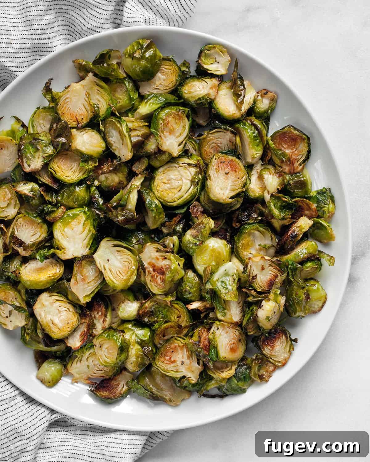 Golden-Crisp Roasted Brussels Sprouts 2 A serving of perfectly roasted crispy Brussels sprouts on a plate, golden brown and inviting.