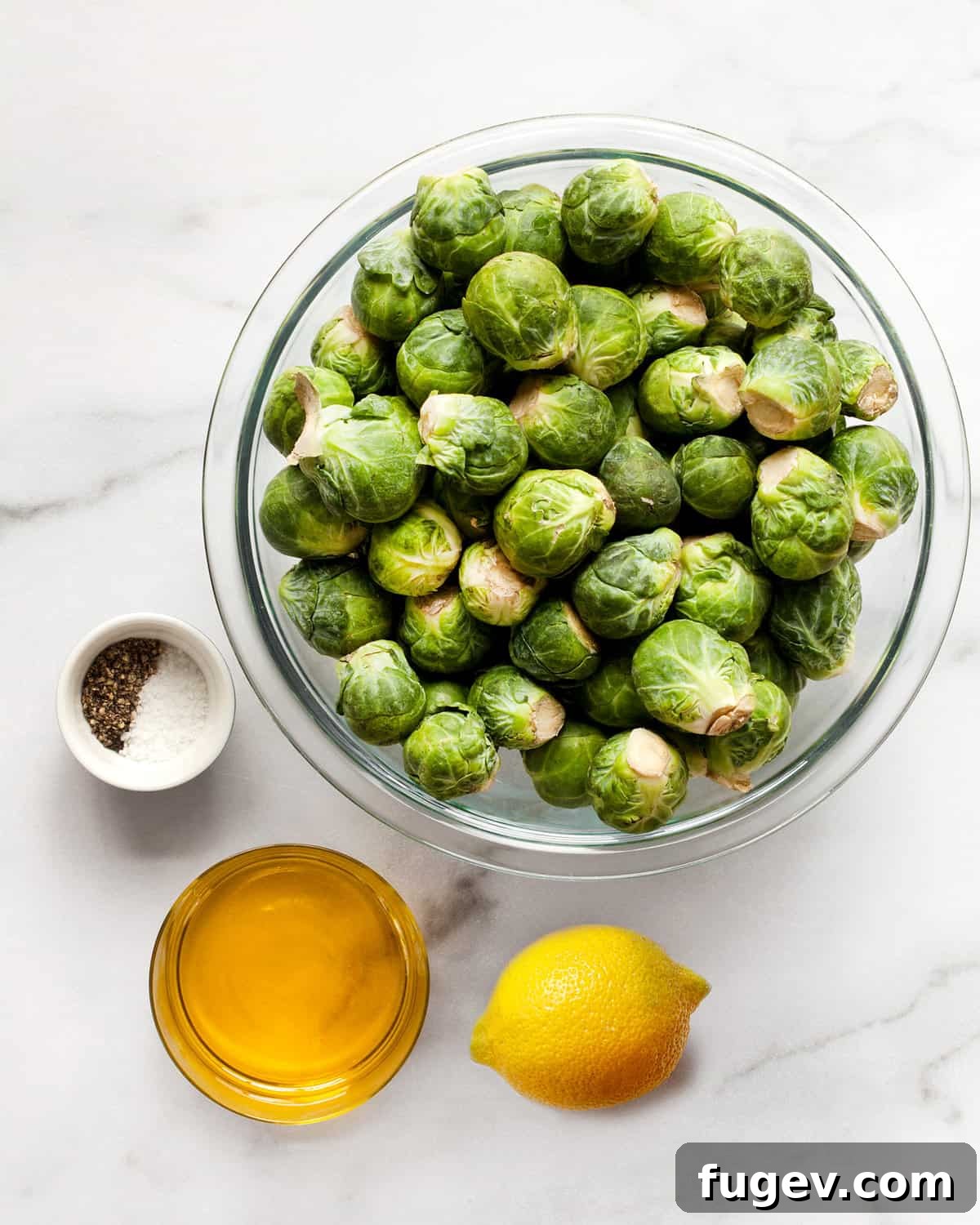 Golden-Crisp Roasted Brussels Sprouts 3 Collection of fresh ingredients for crispy Brussels sprouts: whole sprouts, olive oil, a lemon, salt, and black pepper.