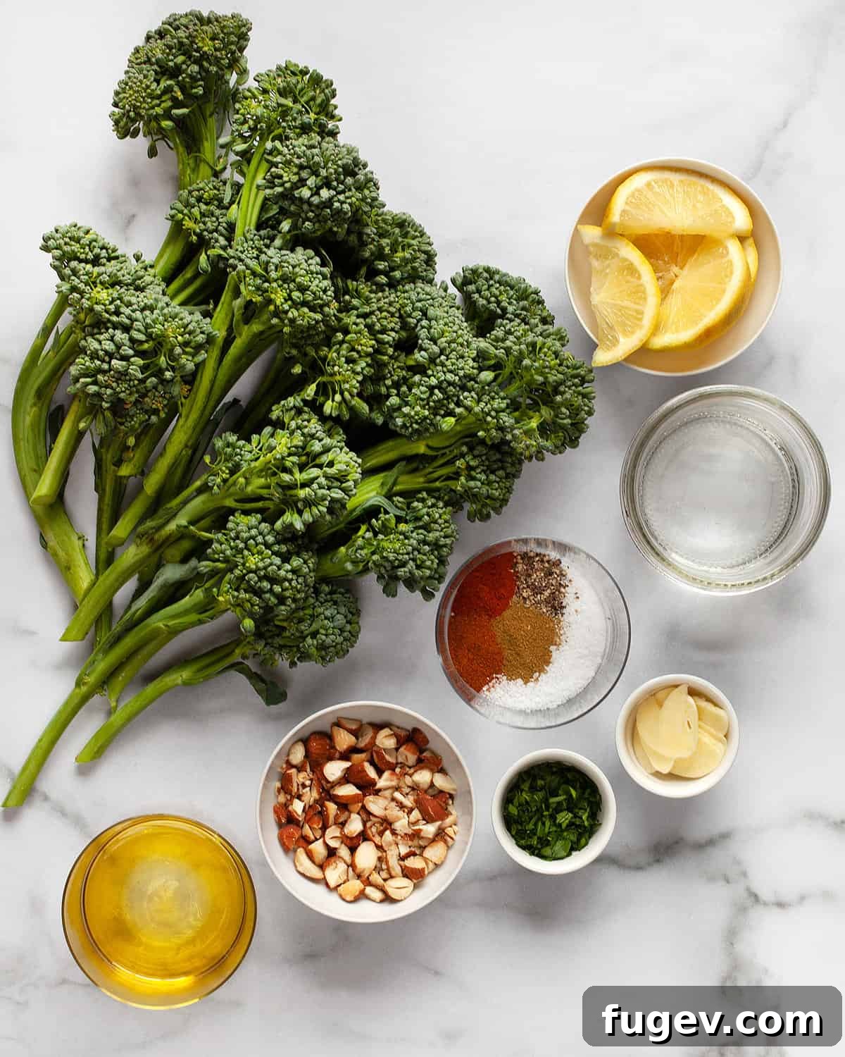 Toasted Almond Broccolini Sauté 3 All the fresh ingredients for sautéed broccolini laid out: vibrant green broccolini, golden olive oil, a selection of spices, crunchy almonds, fresh garlic cloves, and bright lemon wedges.