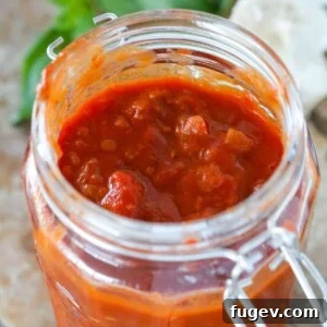 Red Wine Basil Pasta Sauce in a clear mason jar with the lid unlatched.