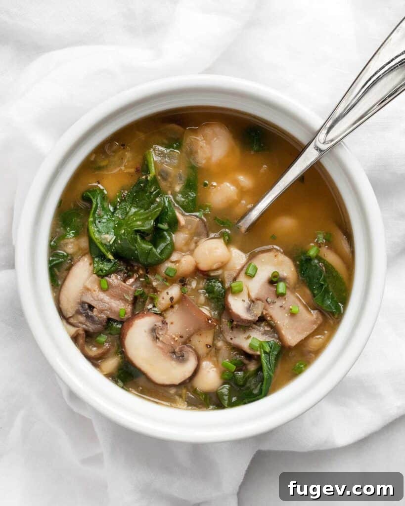Wholesome White Bean Mushroom Spinach Soup 4 Overhead shot of a bowl of White Bean Mushroom Spinach Soup, ready to be enjoyed.