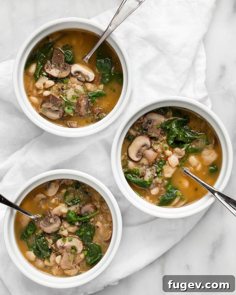 Wholesome White Bean Mushroom Spinach Soup 5 A large pot of White Bean Mushroom Spinach Soup simmering on the stovetop.