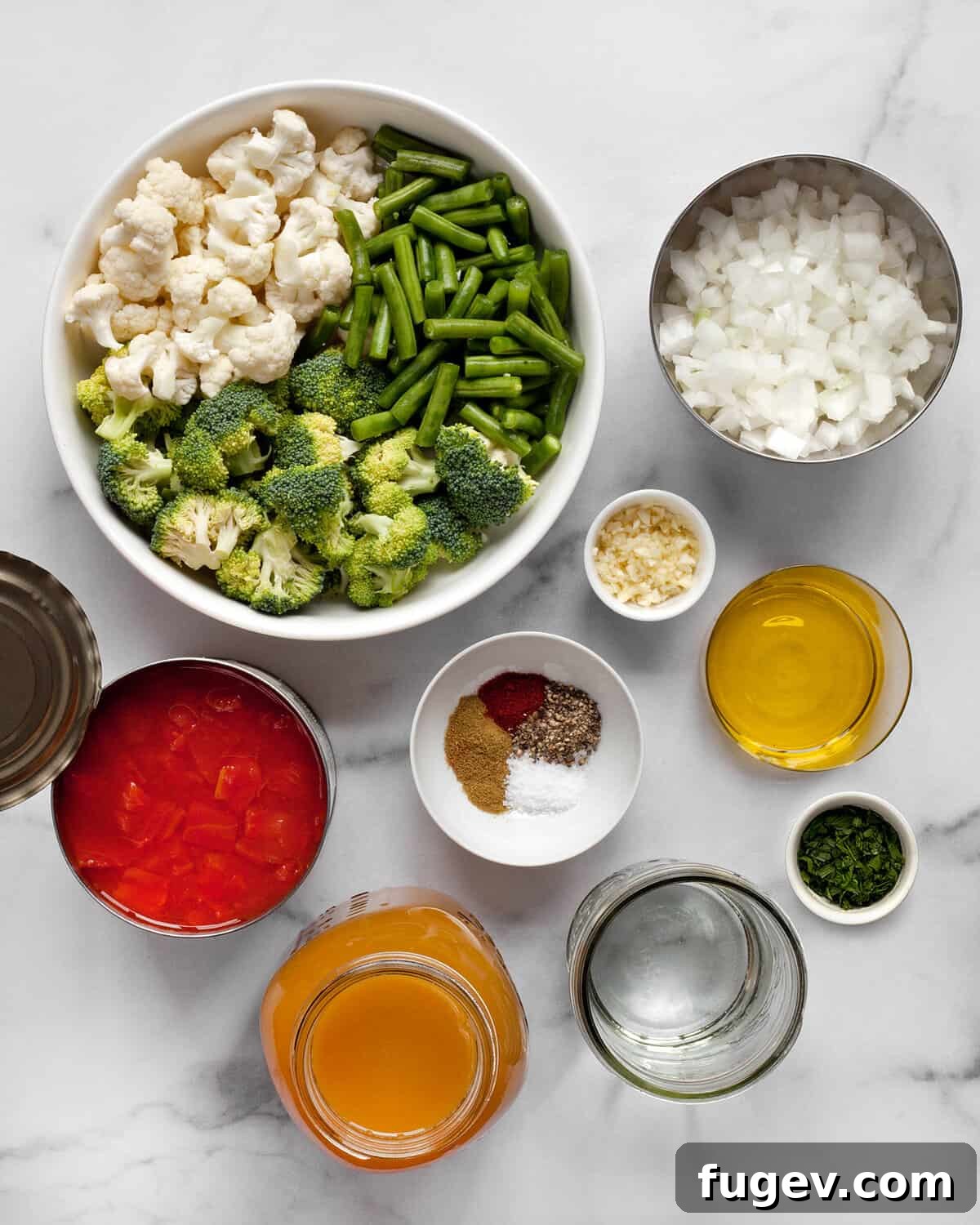 Comforting Harvest Vegetable Soup 3 A vibrant selection of fresh ingredients laid out for hearty vegetable soup: broccoli florets, cauliflower florets, green beans, canned diced tomatoes, fresh onions, garlic cloves, an array of dried spices, olive oil, and vegetable broth.
