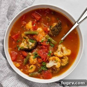 A bowl of Hearty Vegetable Soup with visible broccoli and cauliflower florets.