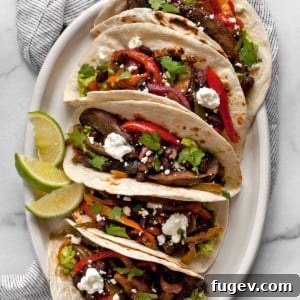 Veggie fajitas on a plate, showcasing the roasted vegetables and fresh toppings.