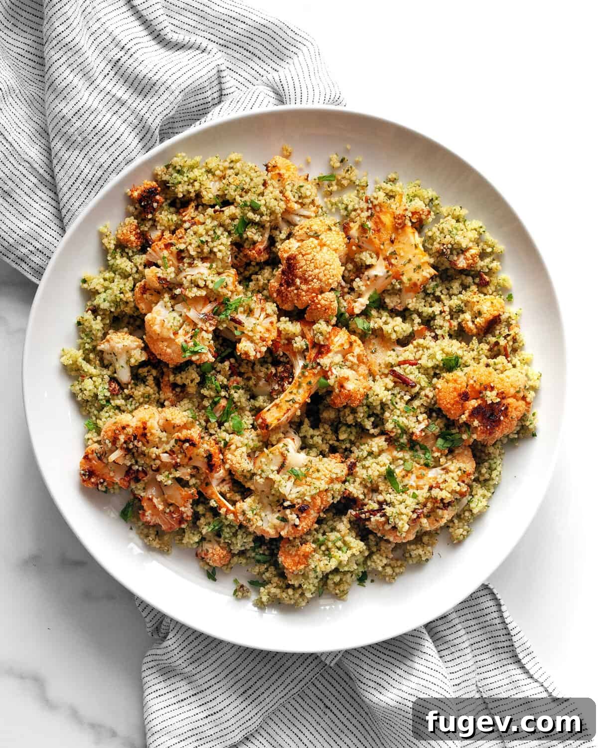Zesty Harissa Roasted Cauliflower Couscous 7 A single serving of Harissa Roasted Cauliflower Couscous presented beautifully on a white plate, garnished with fresh herbs.