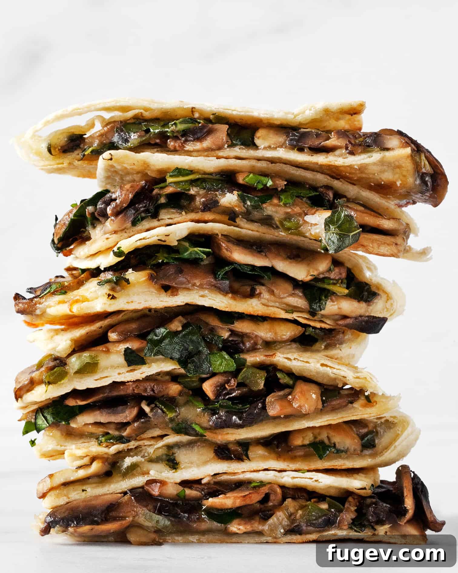 Golden Baked Mushroom Quesadillas 6 A perfectly stacked plate of baked mushroom quesadillas, garnished with fresh cilantro, ready to be enjoyed.