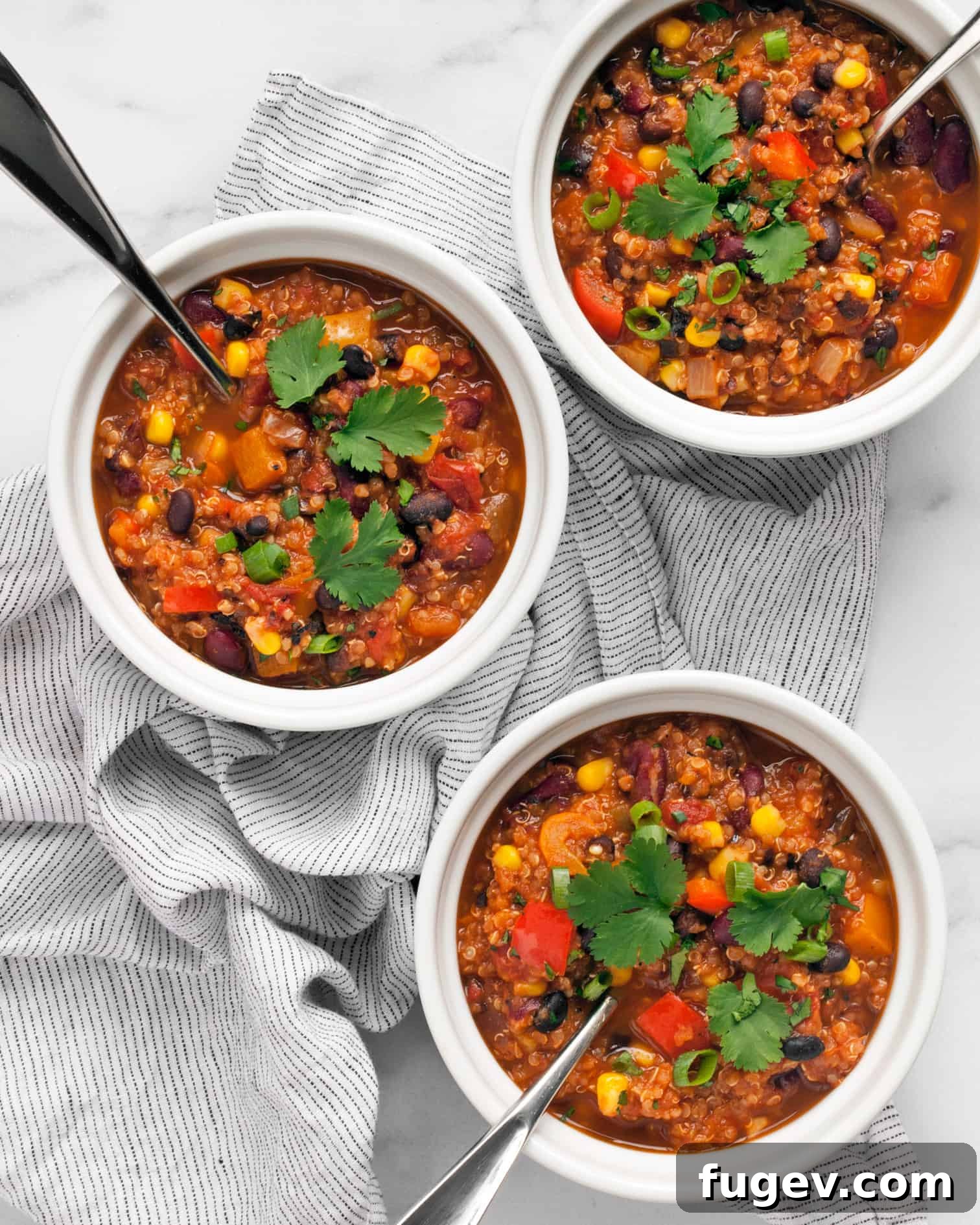 Savory Quinoa Chili with Rich Beans and Golden Corn 7 Three beautifully garnished bowls of vegan quinoa chili, ready to be served.
