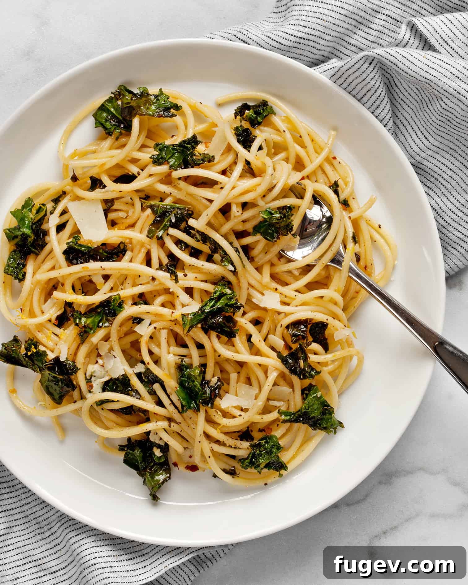 Zesty Lemon Pepper Pasta 6 A beautifully plated dish of lemon pepper pasta with kale, garnished with fresh herbs and a fork ready to twirl.