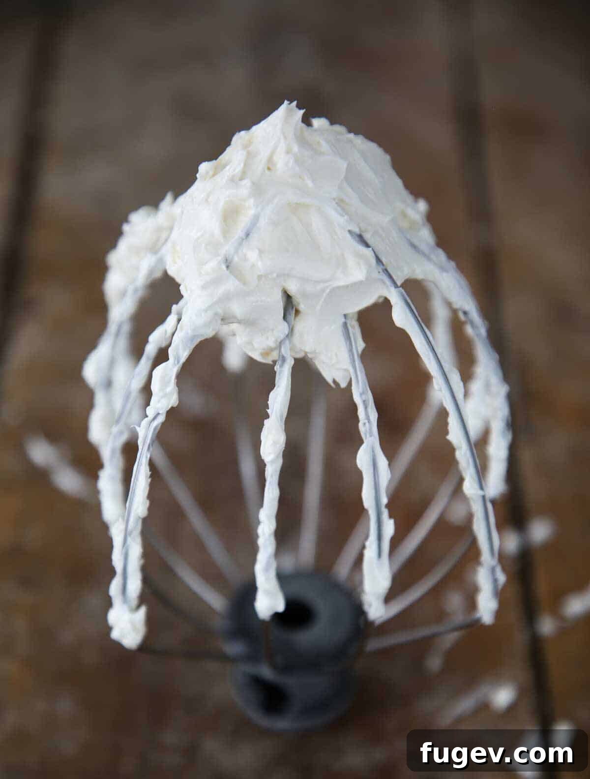 Dreamy Swiss Meringue Buttercream 3 Close-up of fluffy Swiss Meringue Buttercream clinging to a whisk attachment.