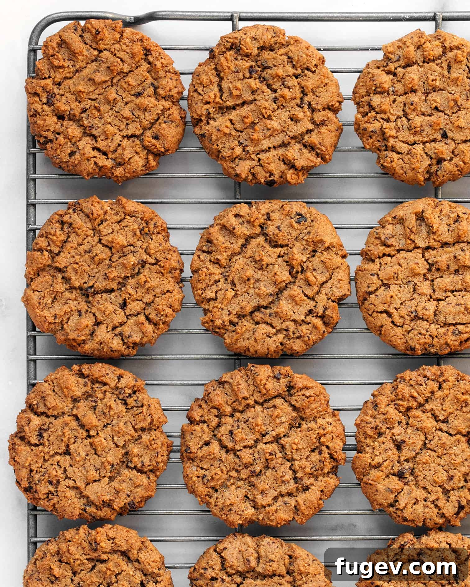 Decadent Peanut Butter Chocolate Chews 5 Freshly baked flourless peanut butter cookies cooling on a wire rack, showing their perfect golden color and textured tops.