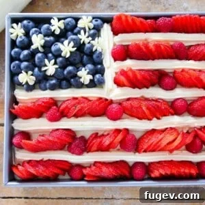Beautifully decorated American Flag Cake with fresh berries and Swiss meringue buttercream, ready for a festive occasion.