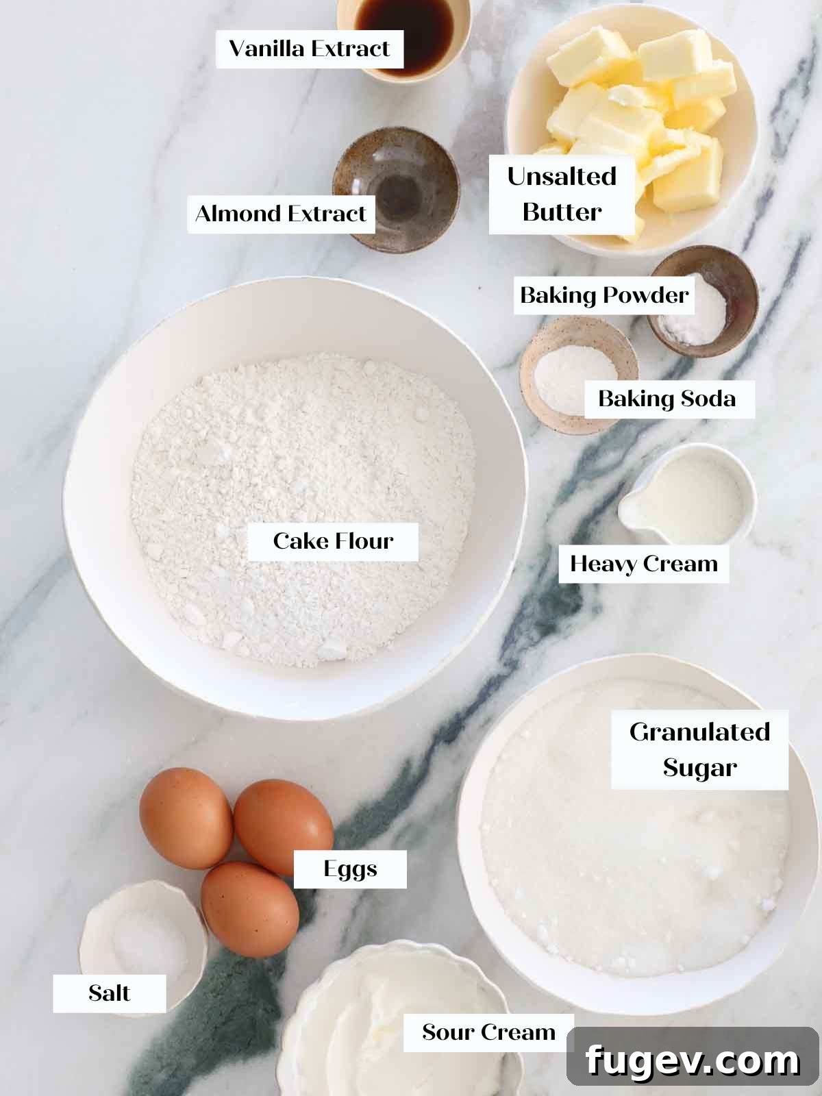 Stars Stripes and Sweetness 3 Moist vanilla cake ingredients, including butter, sugar, eggs, and flour, arranged on a elegant marble surface.