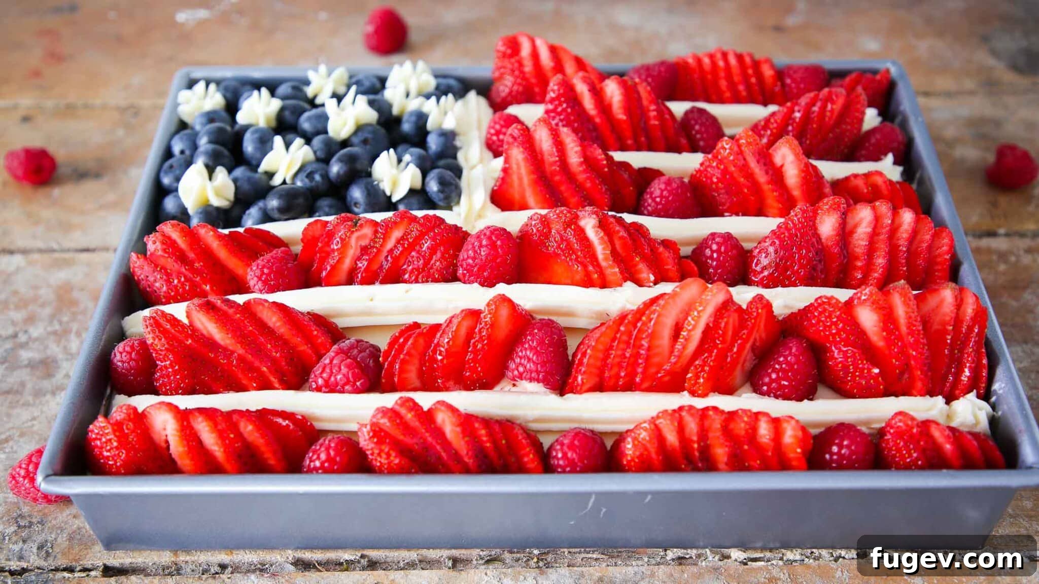 Stars Stripes and Sweetness 4 Side view of an American Flag Cake with berries, showing the alternating layers of red fruit and white buttercream, with a blue field of blueberries.