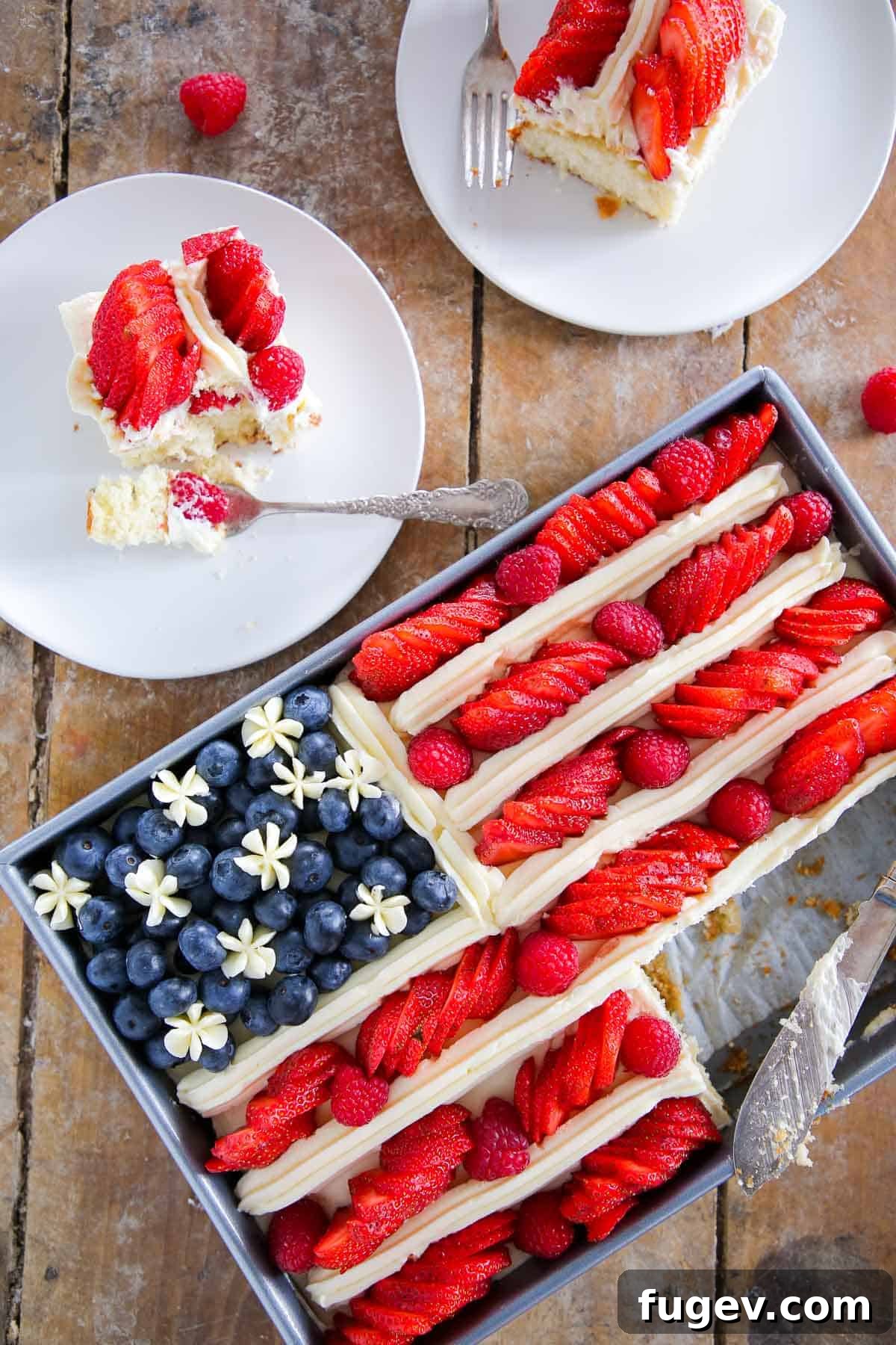 Stars Stripes and Sweetness 8 Sliced American Flag Cake on white plates, showcasing the moist vanilla cake layers, lemon buttercream, and fresh berries.